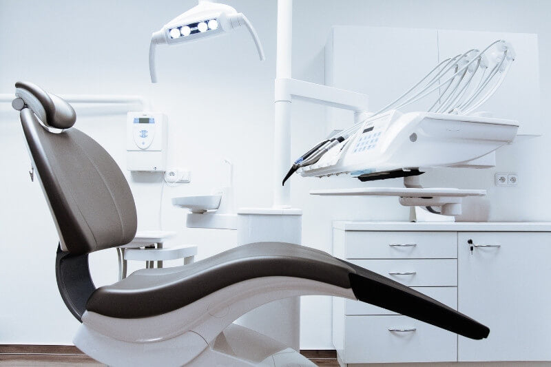 black and white dental chair with light and units in the background