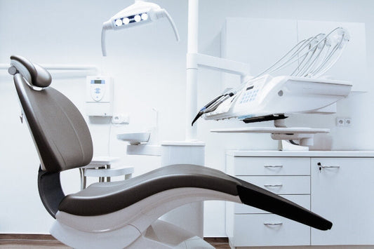 black and white dental chair with light and units in the background
