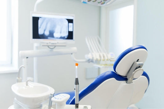 blue and white dental chair and unit with sink to the left and screen in front