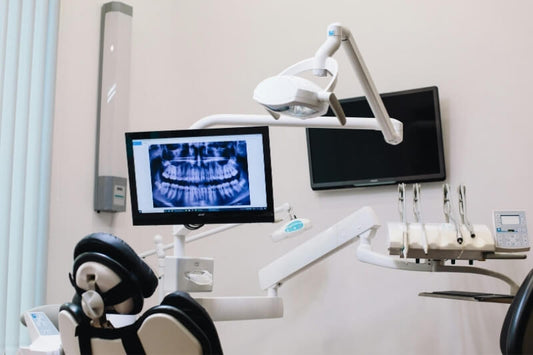 dental chair and unit with x-ray results on screen in the background